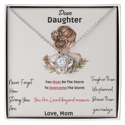 Framed as product alt text: Engraved mother to daughter necklace reading “Never forget how strong you are” with floral motif pendant
