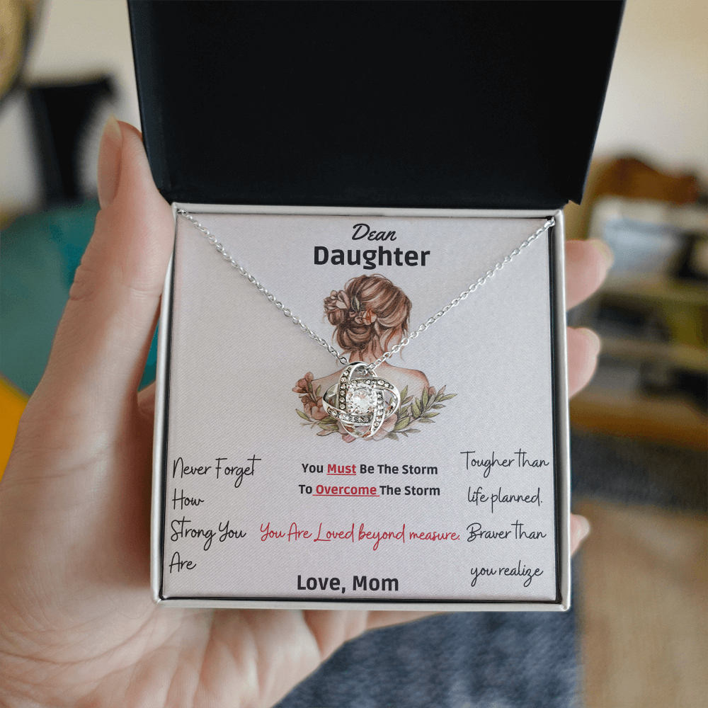 Framed as product alt text: Engraved mother to daughter necklace reading “Never forget how strong you are” with floral motif pendant
