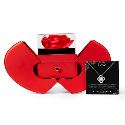 “Heart‑shaped red jewelry box with rose display, holding a silver heart necklace and message card.”